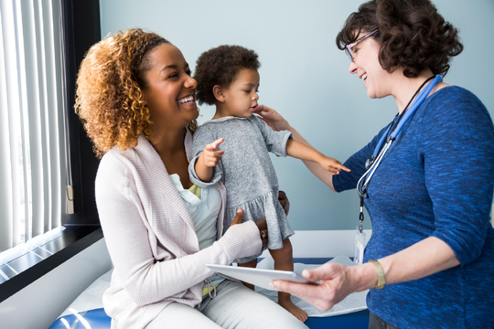 image of a skilled nurse interacting with a baby and mother